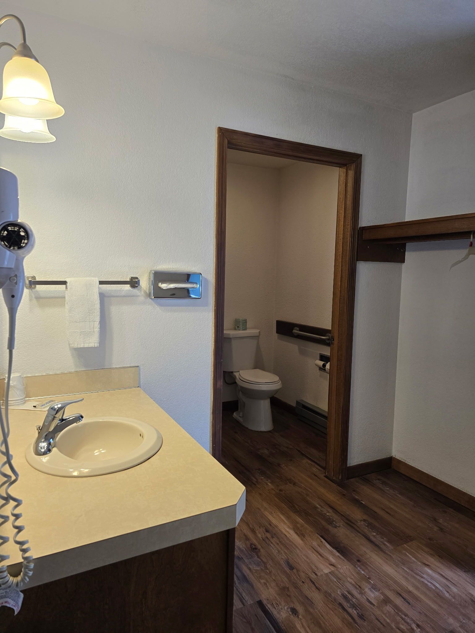 Un baño con lavamanos, inodoro y espejo.