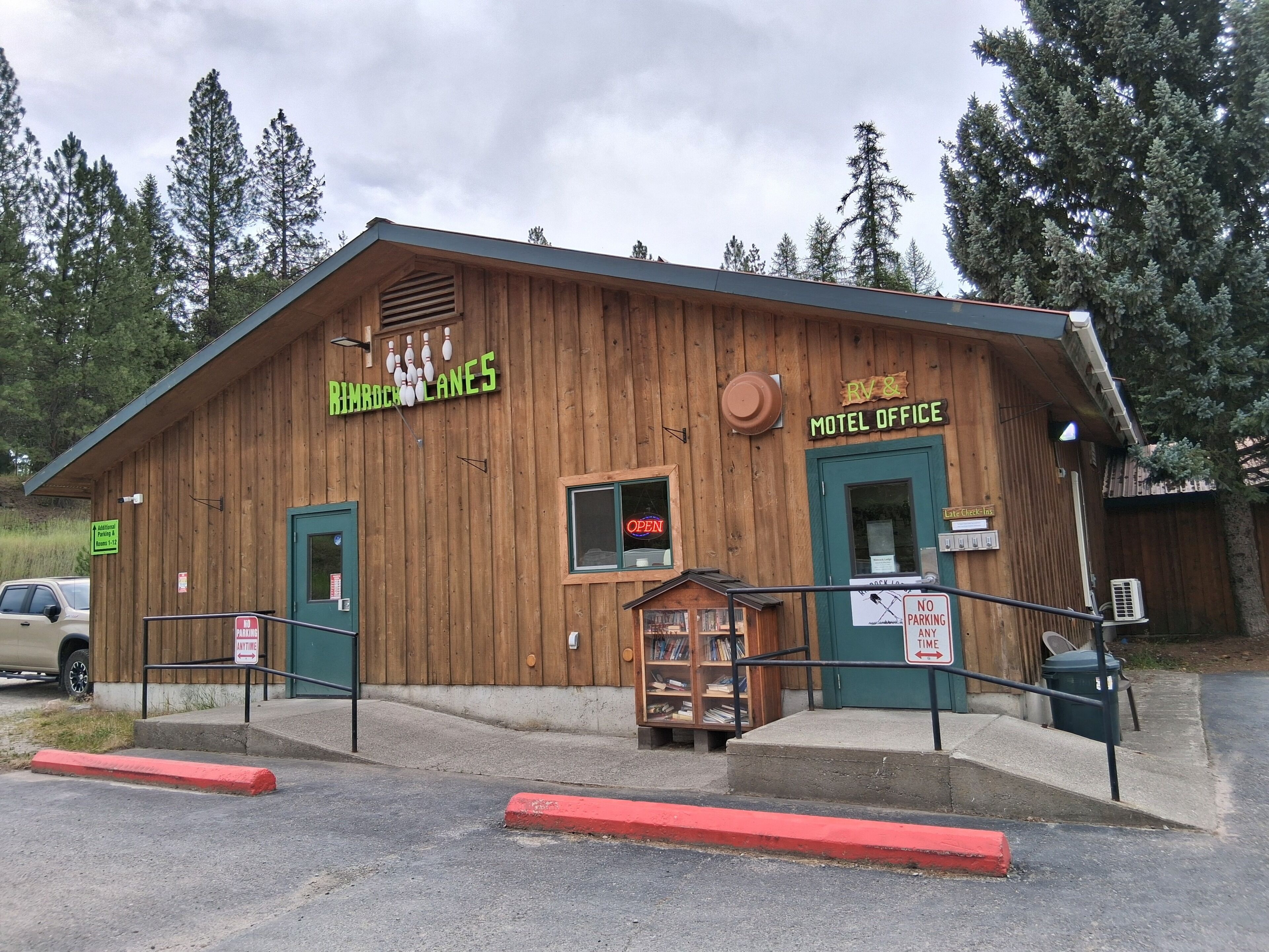 A wooden building with signs for 'BIMBOCK LANES' and 'RV & Motel Office.'