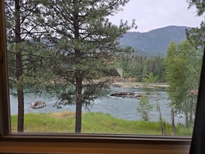 A river with trees and mountains in the background. - Rimrock Lodge (Thompson Falls)