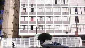 Ein mehrstöckiges Gebäude mit einheitlicher Fassade, Balkonen und einem verschlossenen Eingang.