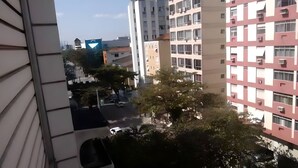 Ein Mehrfamilienhaus mit mehreren Etagen, Balkonen und Blick auf die Straße.