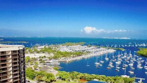 A marina with numerous boats, a clear blue sky, and a view of the ocean. - Balcony Ocean Views | Pool, Gym, Wi-Fi & Parking (Miami)