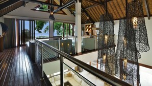 A spacious interior with a high ceiling, wooden flooring, and a balcony with a view of the outdoors. - Luxury Beach & Cliff Villa with Unbelievable Panoramic Views.  (Seririt)