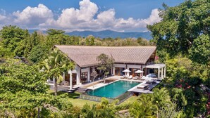 A resort with a pool, outdoor seating, and lush greenery. - Luxury Beach & Cliff Villa with Unbelievable Panoramic Views.  (Seririt)