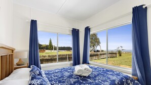 A bedroom with a large bed, a view of the outdoors, and a wooden headboard. - 🏖️ Absolute Beachfront Long Beach -The Beach Is Your Backyard Pet Friendly (Long Beach)