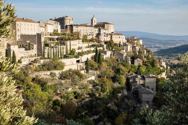 Un pueblo histórico con edificios de piedra, calles estrechas y una imponente estructura que recuerda a un castillo.