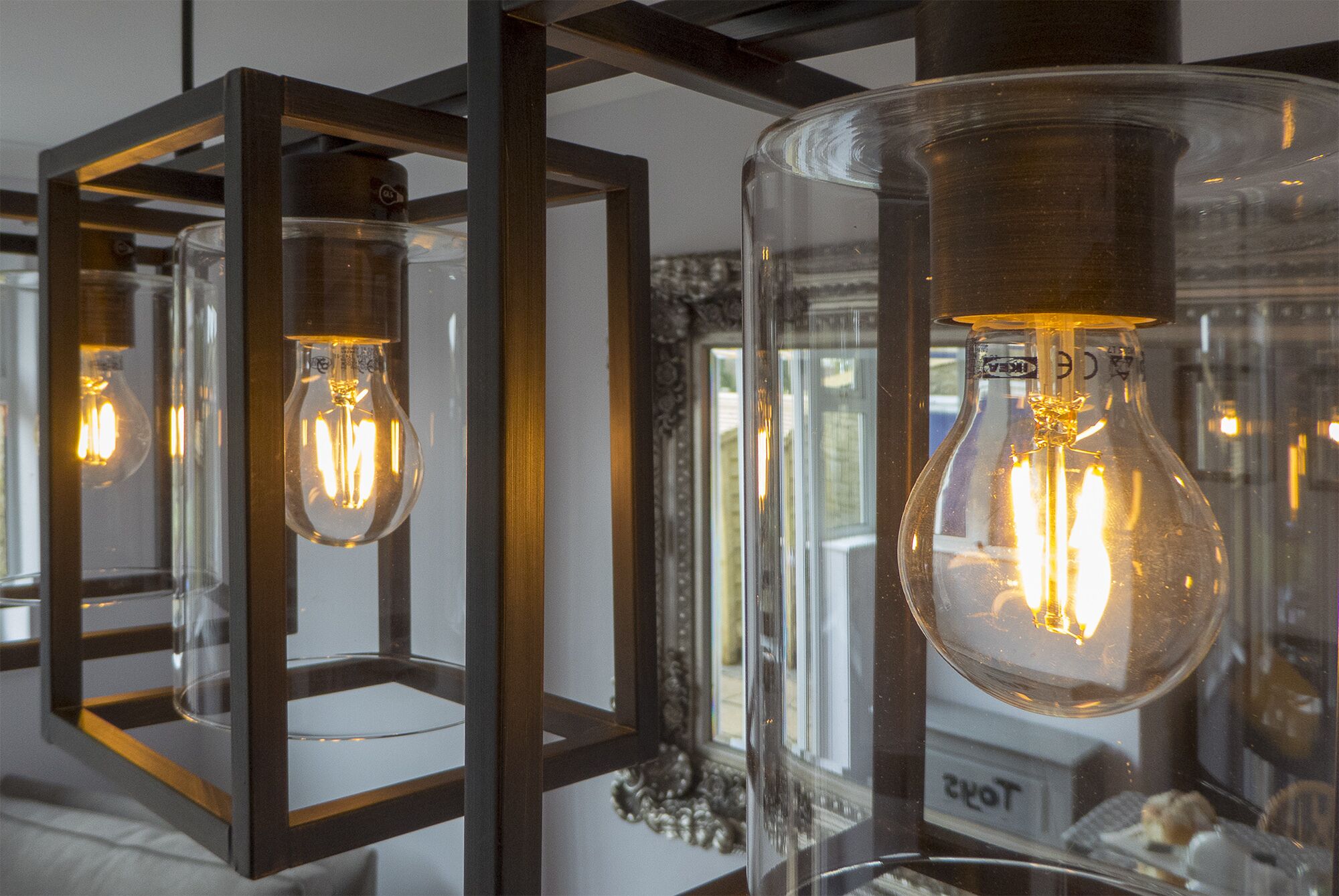 A series of light bulbs encased in clear glass bulbs with metal frames, mounted on a wall.