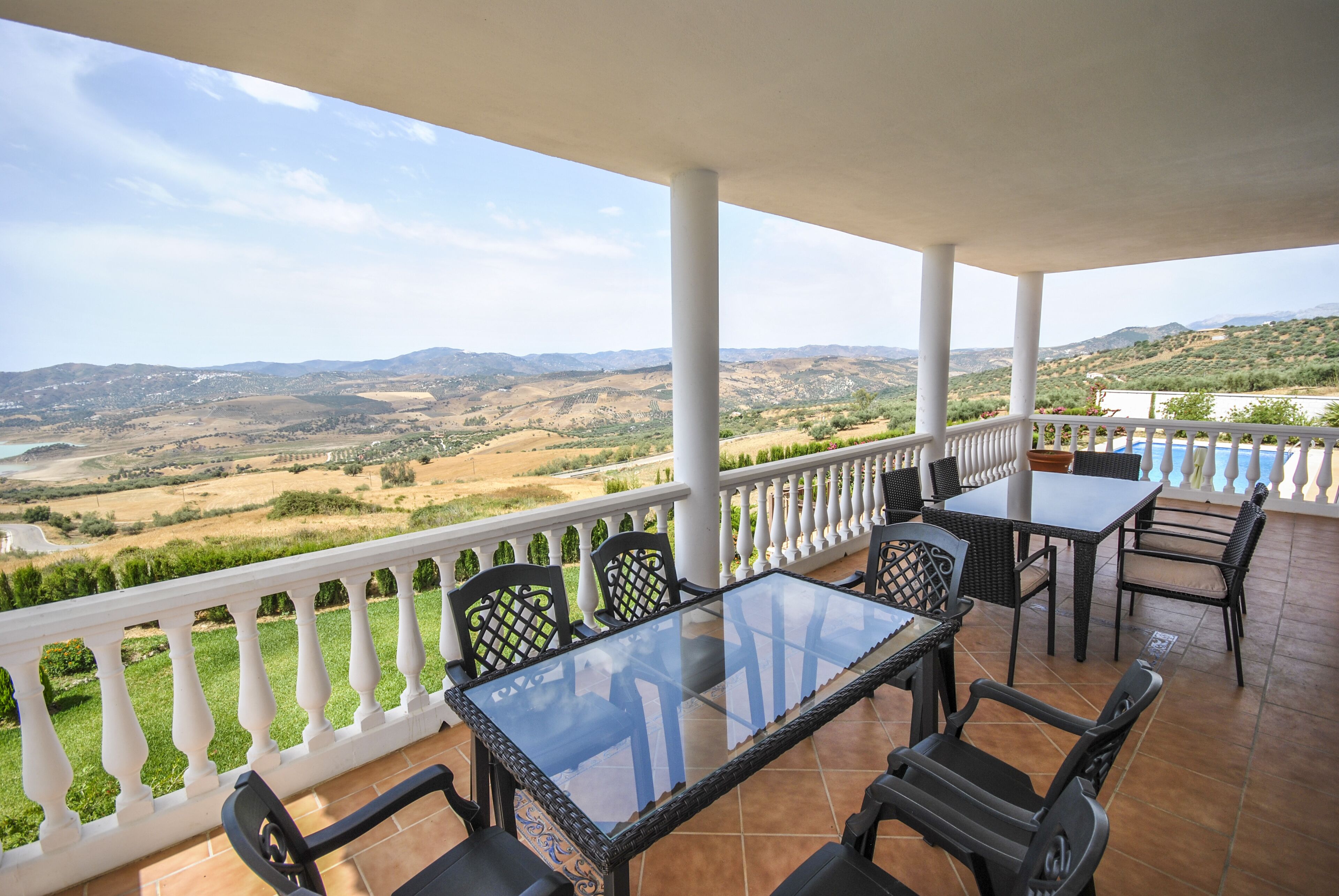Un espace extérieur abrité, avec une table et des chaises, offrant une vue sur un paysage pittoresque.