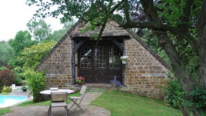 A stone cottage with a pool and patio furniture. - Cottage with shared swimming pool, hot tub, fishing, tennis, UK TV and Wi-F (Guerquesalles)
