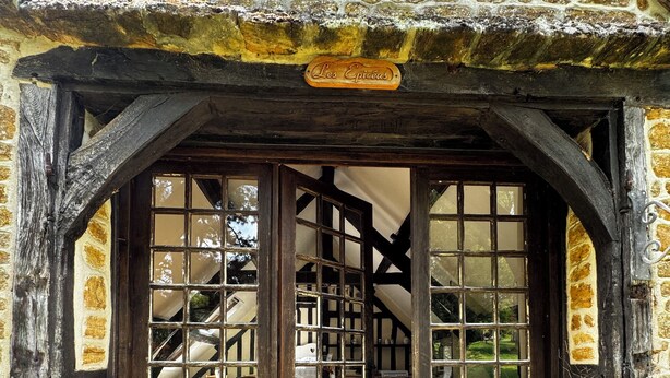 A stone building with a wooden door and a sign reading "Les Epices". - Cottage with shared swimming pool, hot tub, fishing, tennis, UK TV and Wi-F (Guerquesalles)