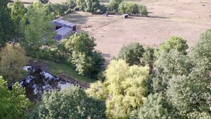 An aerial view of a farm with a barn, open fields, and a small stream. - Au Bas Chalonge l'Appart (Ligné)