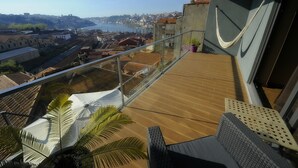 Een balkon met uitzicht op een stadsgezicht, met gebouwen en een waterpartij.