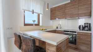 Une cuisine moderne avec des meubles en bois, un plan de travail blanc et un four encastré.