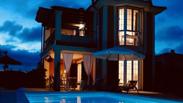 Une maison à deux étages avec une piscine à l’avant.