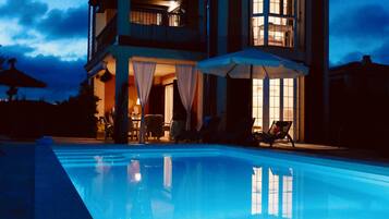 Una piscina al aire libre, tumbonas