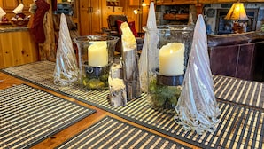 Un interior acogedor con una zona de bar de madera, una chimenea de piedra y velas en candelabros de vidrio.