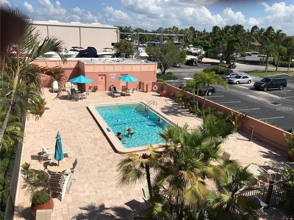 A hotel pool area with lounge chairs, umbrellas, and a swimming pool.