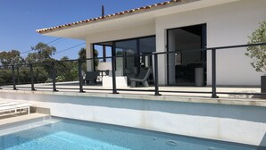 A modern house with a swimming pool, outdoor furniture, and a patio area. - MODERN HOUSE PORTO VECCHIO AIR-CONDITIONED PRIVATE POOL SUPERB SEA/MOUNTAIN VIEW (Zonza)