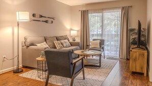 A living room with a sofa, two armchairs, a coffee table, a lamp, and a TV stand. - First Floor, Updated, and a Short Walk to the Beach (Hilton Head Island)