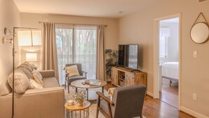 A modern living room with a sofa, armchairs, a coffee table, and a TV. - First Floor, Updated, and a Short Walk to the Beach (Hilton Head Island)
