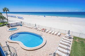 A pool area with a large pool, smaller pools, and lounge chairs.