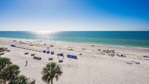 Une plage dotée de nombreuses chaises longues et offrant une vue dégagée sur l’océan.