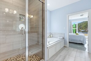 Een bad/douchecombinatie, een bubbelbad, een haardroger, handdoeken
