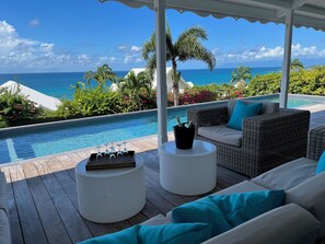 A covered outdoor area with a pool, wicker furniture, and a view of the ocean. - Bagataye Villa - exceptional 180° view of sea and islands, 100 m from the sea (Sainte-Anne)