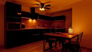 Una cocina moderna con comedor, piso de madera y ventilador de techo.