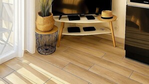 Una sala de estar moderna con un televisor de pantalla plana, una chimenea y una zona de cocina.