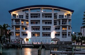 A multi-story hotel with balconies, a dock area, and a thatched-roof structure. - Spacious Waterfront, 3 BR/3 BA, Water Views, Walk to All (Clearwater Beach)