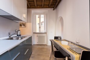 Una cucina moderna con forno a incasso, lavello e finestra.