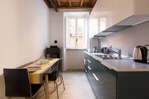 Eine kompakte Küche mit Essbereich, inklusive Fenster, modernen Geräten und minimalistischem Design.