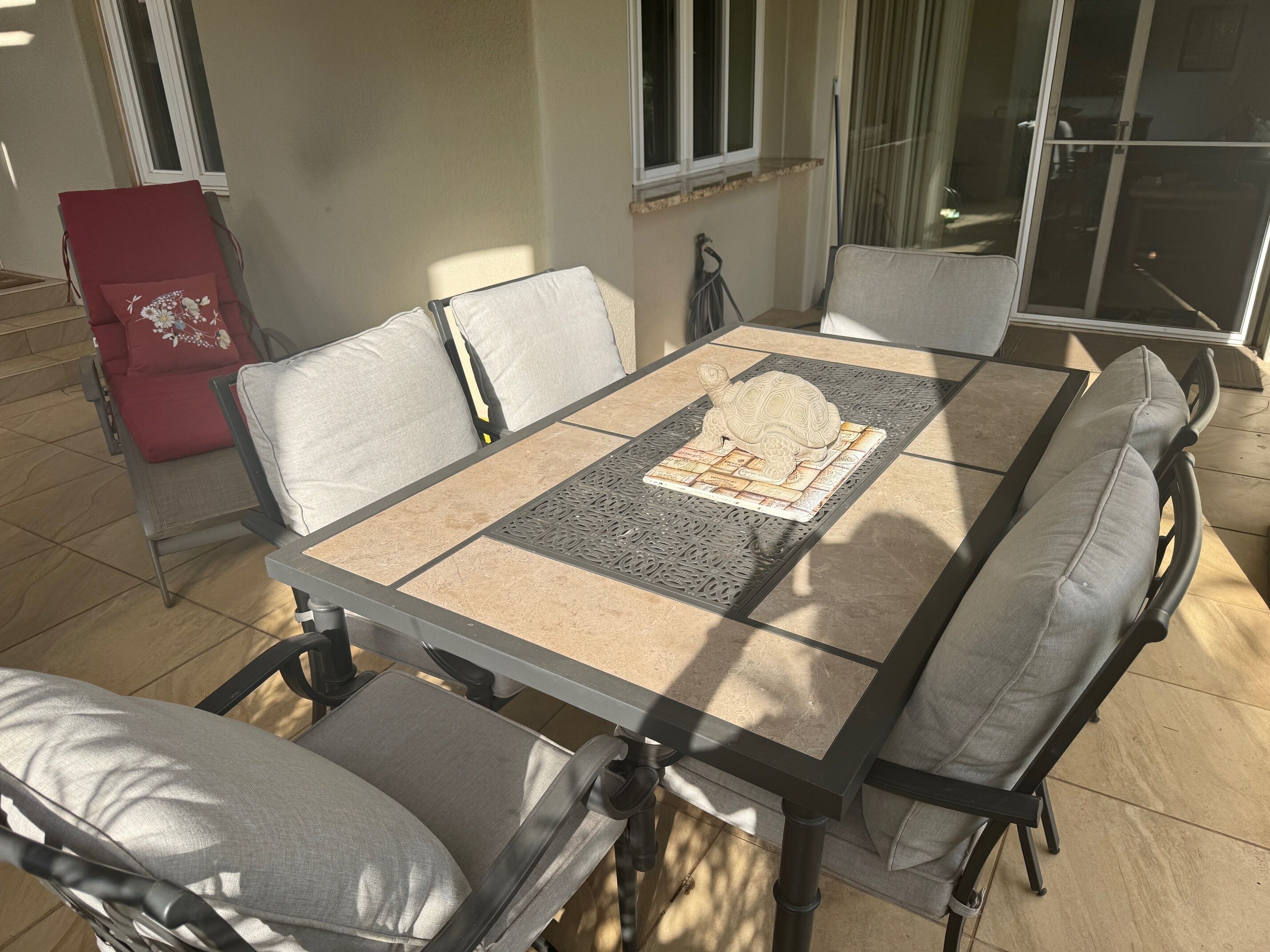 A dining table with a decorative tile centerpiece, surrounded by cushioned chairs.