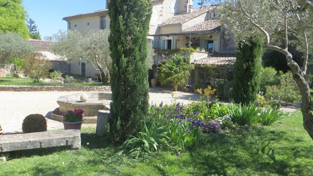 A traditional stone building with a courtyard, surrounded by greenery and flowering plants. - COTTAGE WITH HEATED POOL - MAS IN THE GARRIGUE D'UZES (Fons-Sur-Lussan)