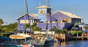 Experience waterfront living with a nautical twist, featuring a dock and sailboat model, and offering paddleboard tours.