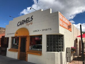 Un edificio con un letrero que dice 'CARMELS Flagstaff' y 'ALMUERZO • BEBIDAS'.