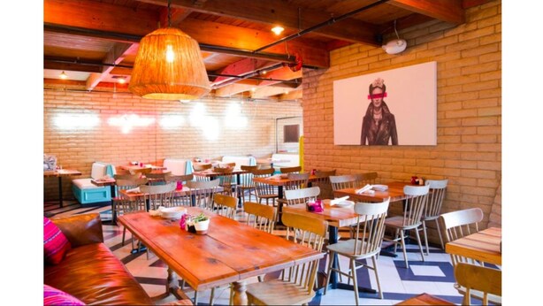 Un restaurant aux murs de briques, aux tables et aux chaises en bois.