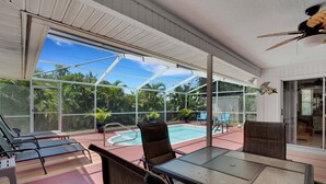 A covered outdoor area with a pool, lounge chairs, and a table. - IMMACULATE 3BR 2 BATH PRIVATE POOL HOME MINUTES TO BEACHES, DOWNTOWN.  (Venice)