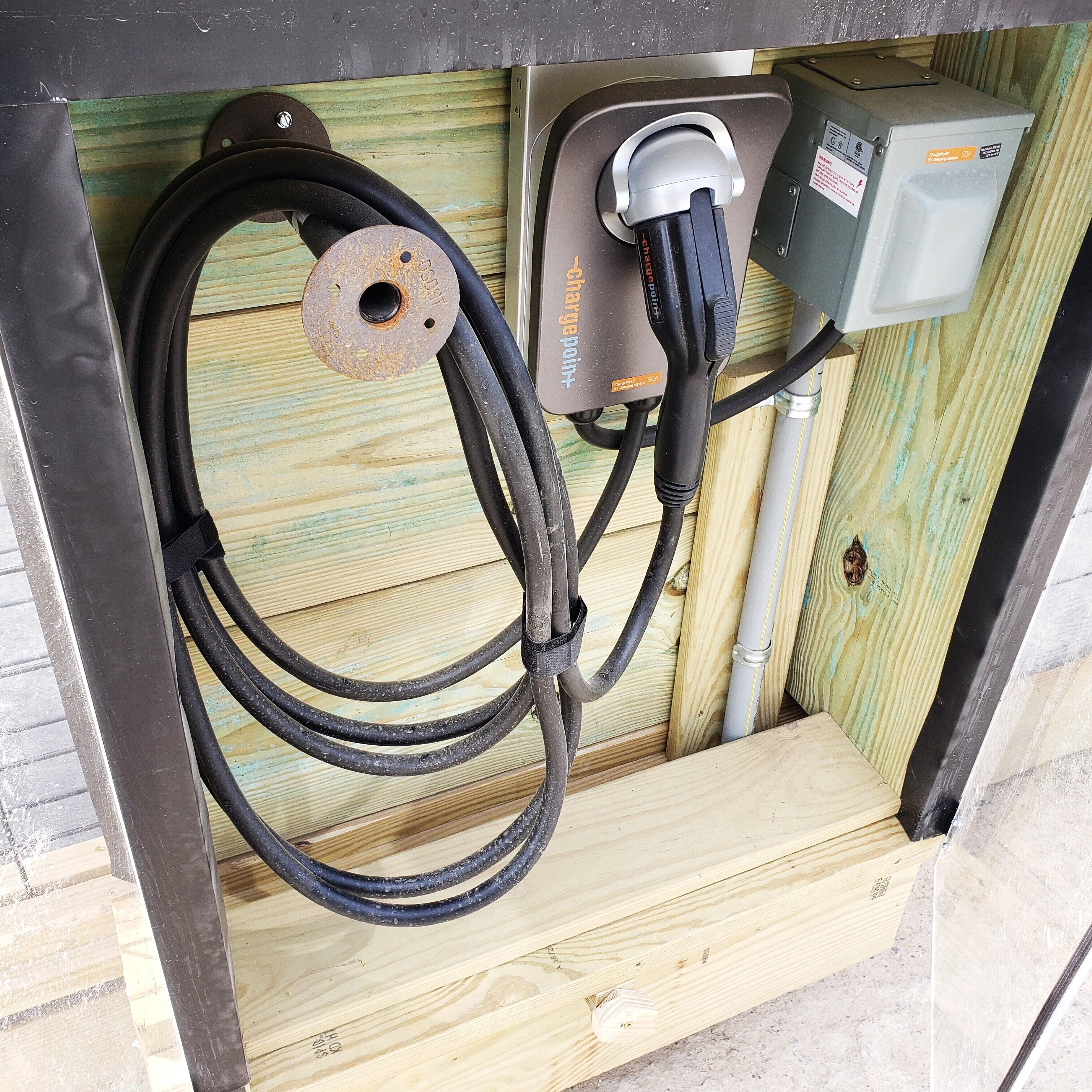 A power outlet with a plug connected to a coiled cable.
