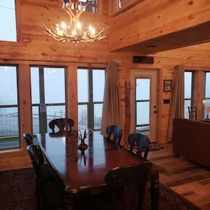 Ein Holzinterieur mit einem Esstisch, Stühlen und einer Chandelüster.