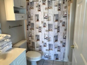 Bathtub, hair dryer, towels, toilet paper
