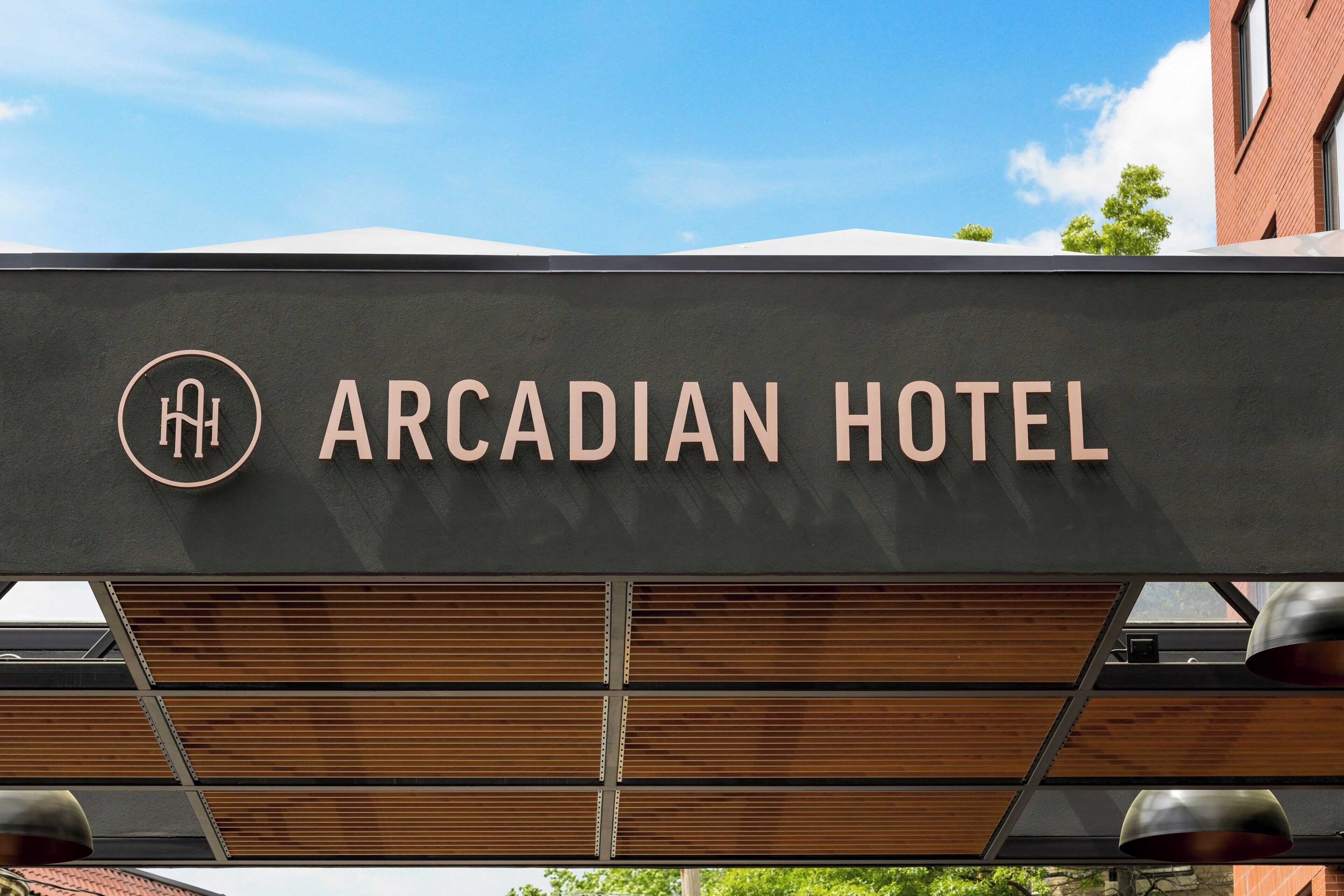 A sign for the Arcadian Hotel with a modern design and a logo.