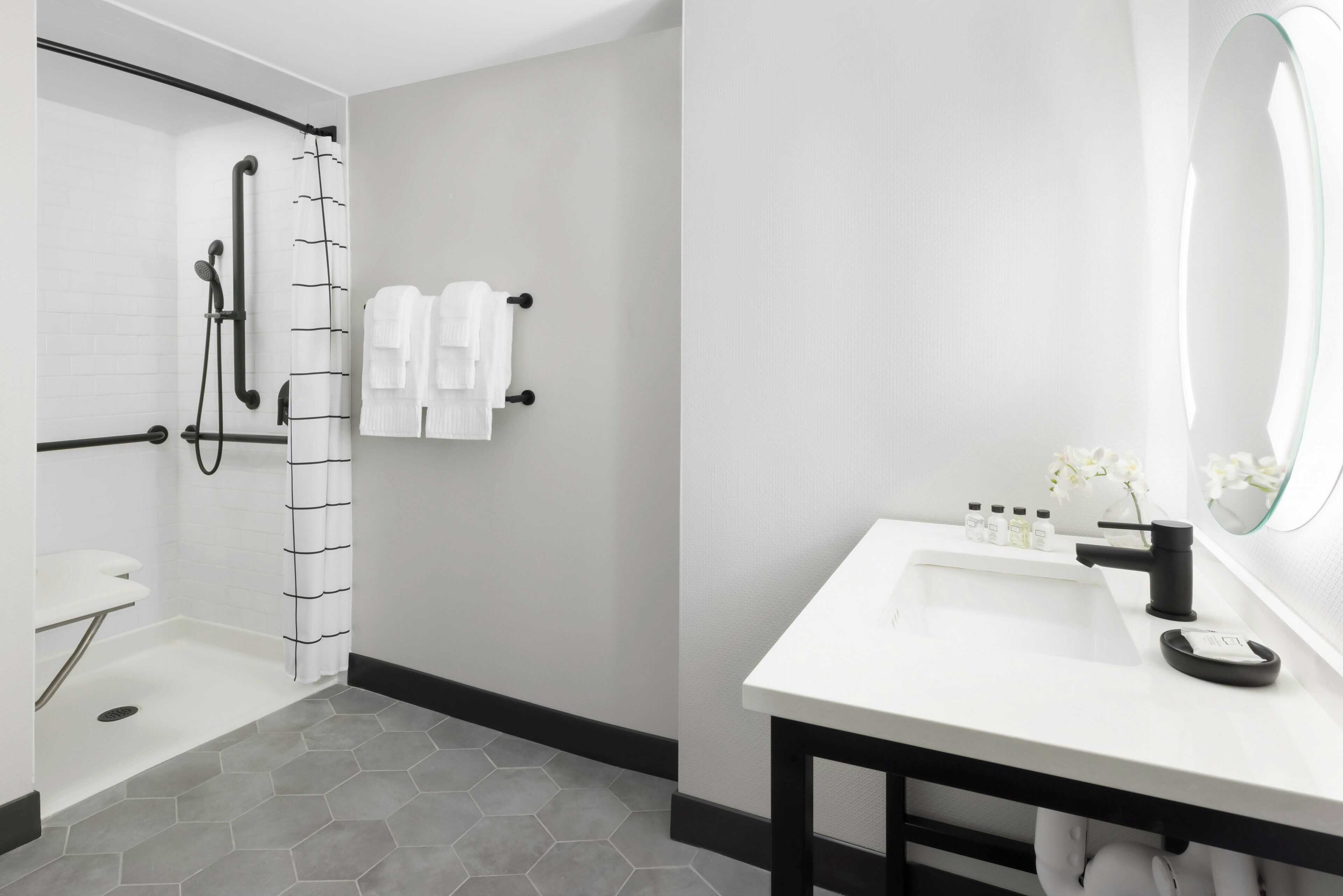 A modern bathroom with a shower, toilet, and sink.