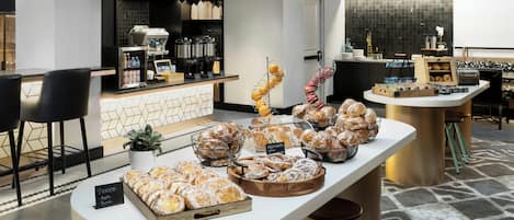 A buffet area with various baked goods and a coffee station.