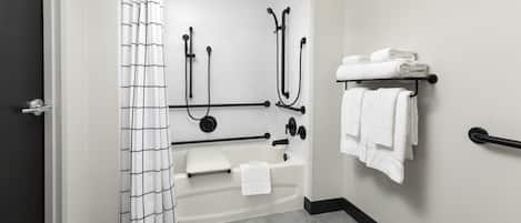 A modern bathroom with a shower, a bathtub, and a towel rack.