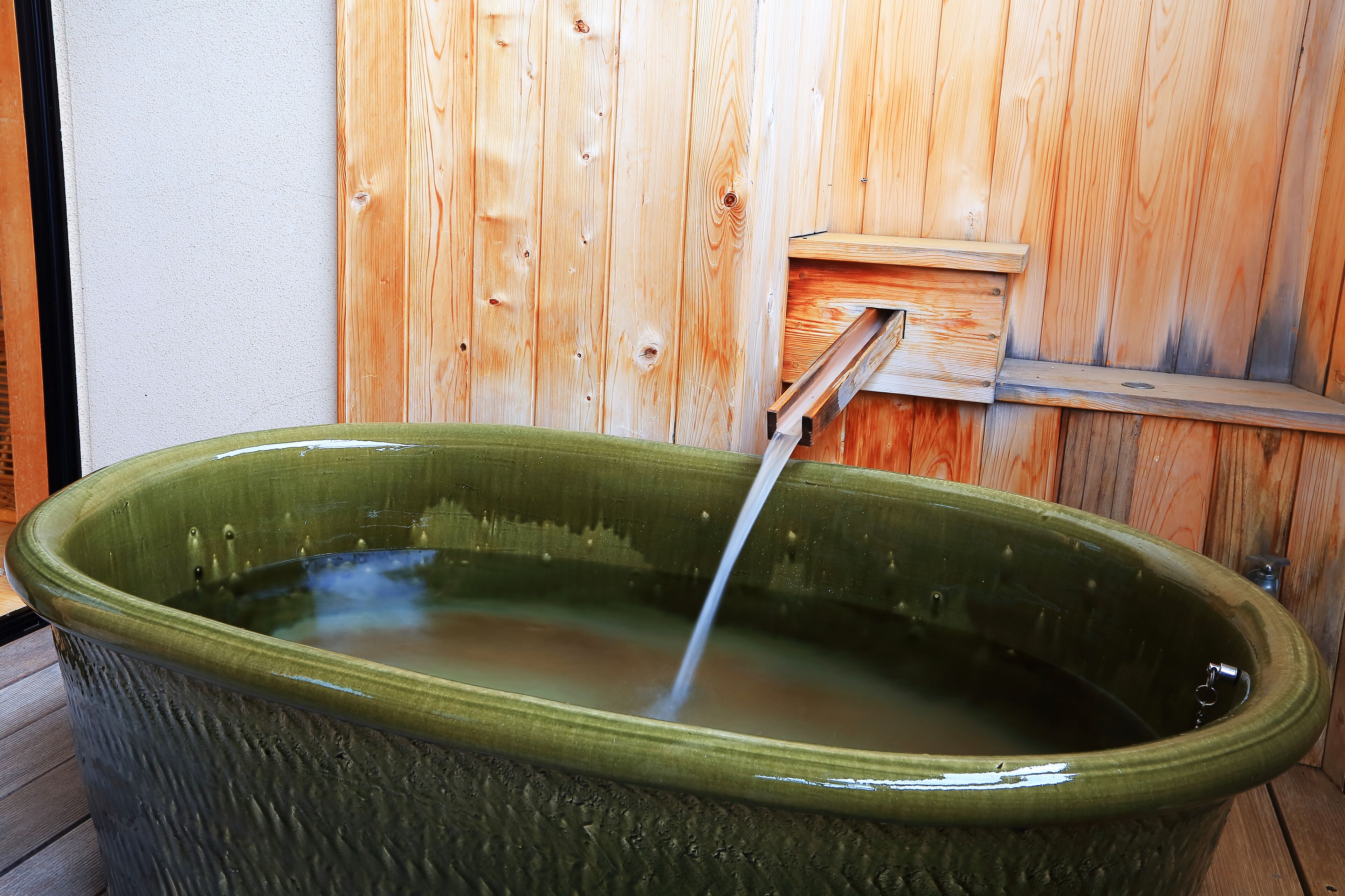 Un jacuzzi de cerámica grande con fondo de madera.