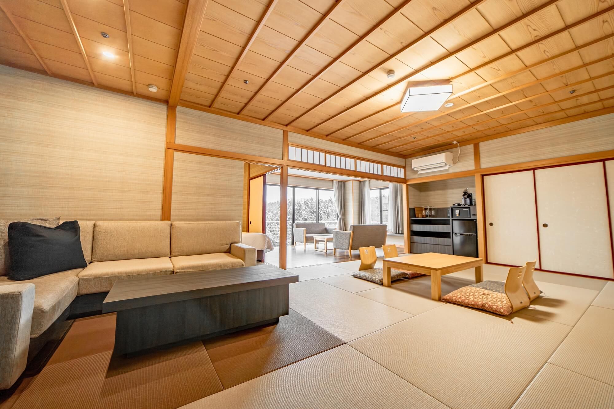 A traditional Japanese-style room with tatami flooring, a low wooden ceiling, and a sliding door leading to a balcony.