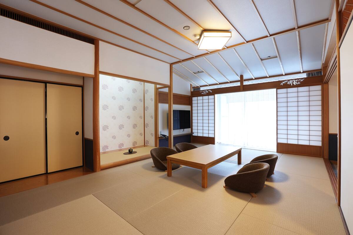 A traditional Japanese room with tatami flooring, a low wooden table, and shoji screens.