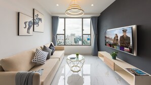 Una sala de estar moderna con sofá, mesa de centro y televisor.